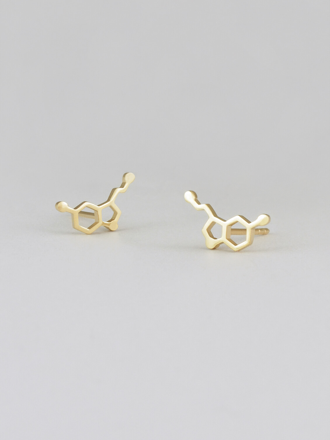 Die Ohrstecker Serotonin Molekül kombinieren minimalistisches Design mit einer wissenschaftlichen Symbolik. Das filigrane Serotonin-Molekül steht für Glück und Ausgeglichenheit und macht diese Ohrstecker zu einem einzigartigen Accessoire. Tragen Sie die Serotonin Molekül Ohrstecker, um stilvoll Ihre Liebe zur Wissenschaft und positiven Energie zu zeigen.